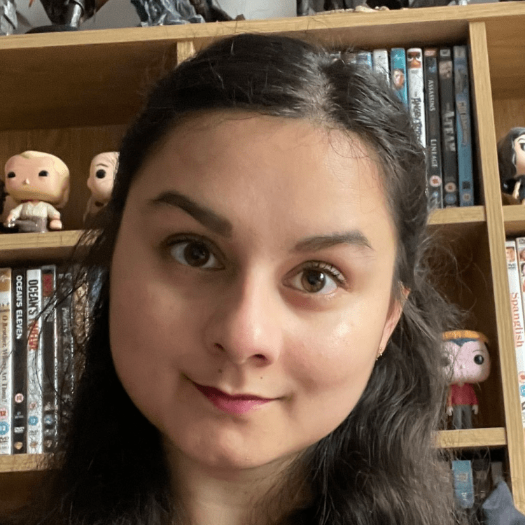 Vanessa in front of a book shelf filled with DVDs and collectable figurines.