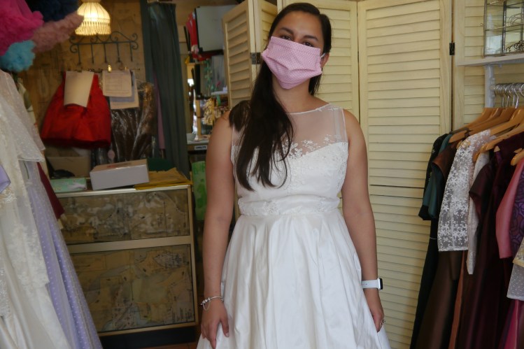 I am wearing a white dress with floral lace and no sleeves.